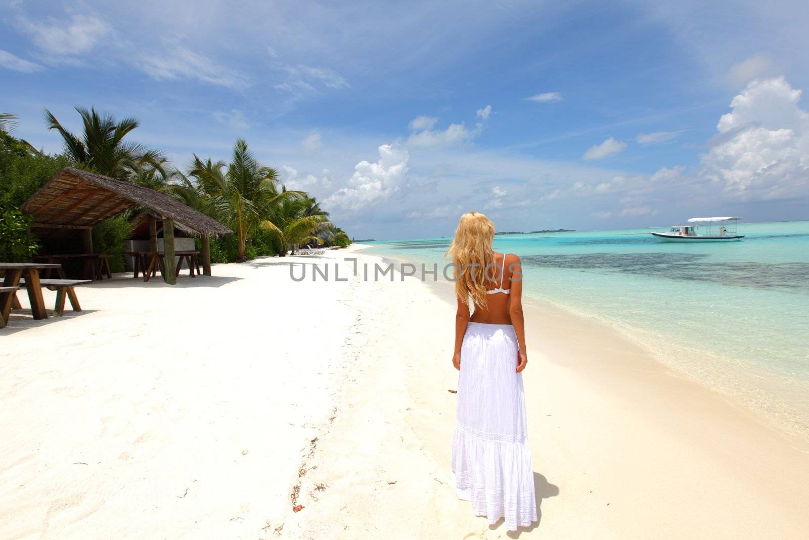 happy woman in a white dress on the ocean coast