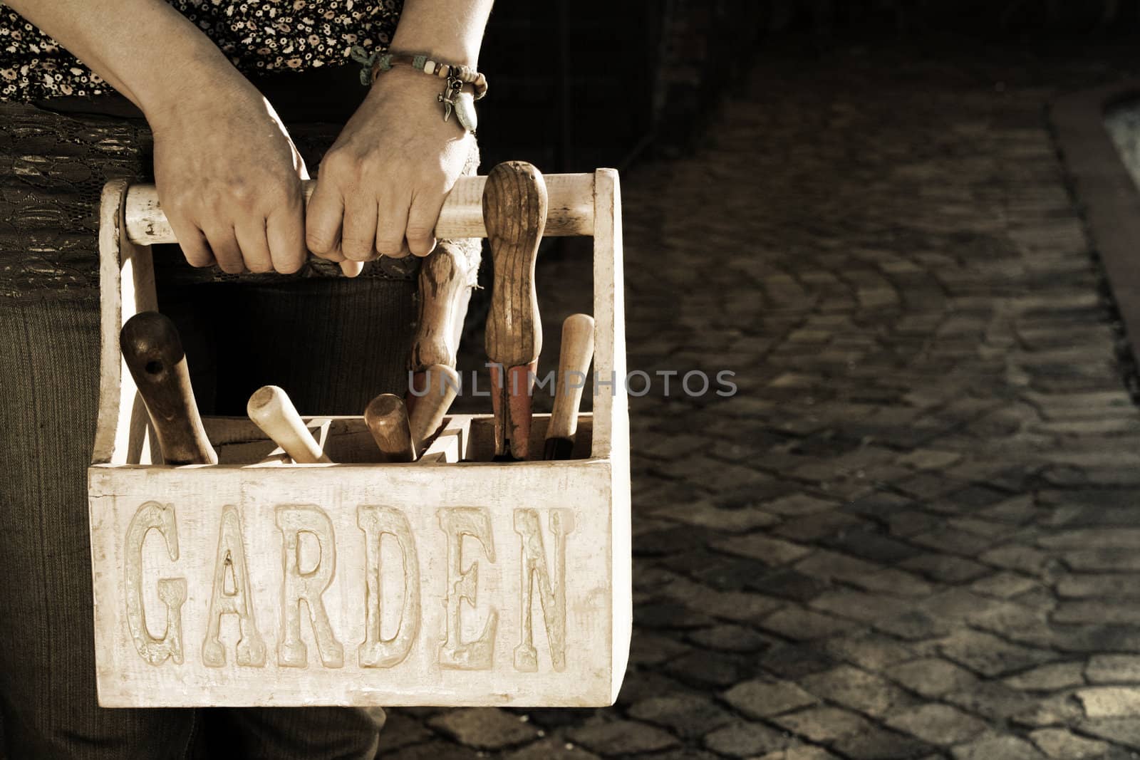 Lady carrying a garden basket with tools