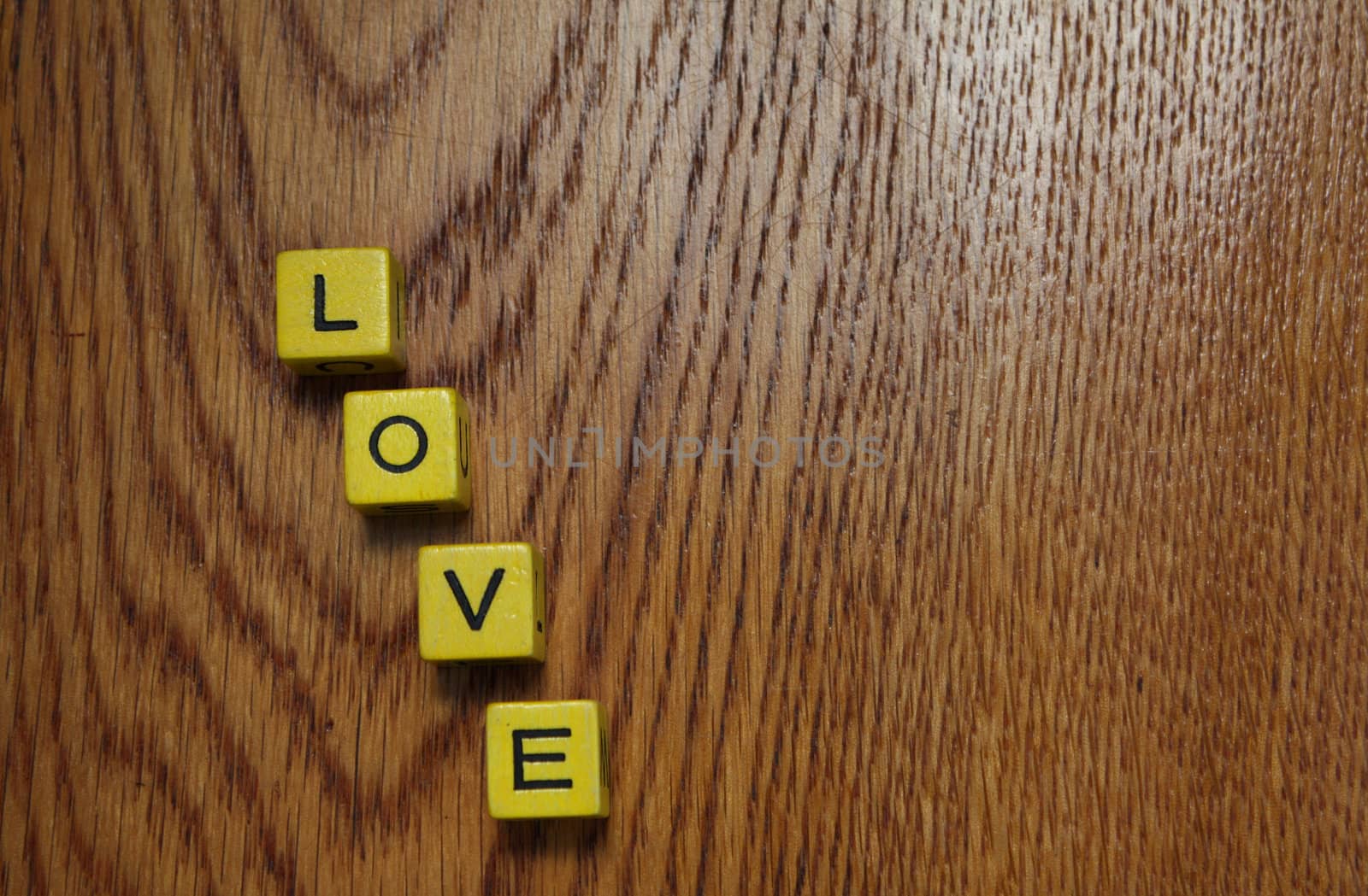 Four blocks on a wooden surface spelling love