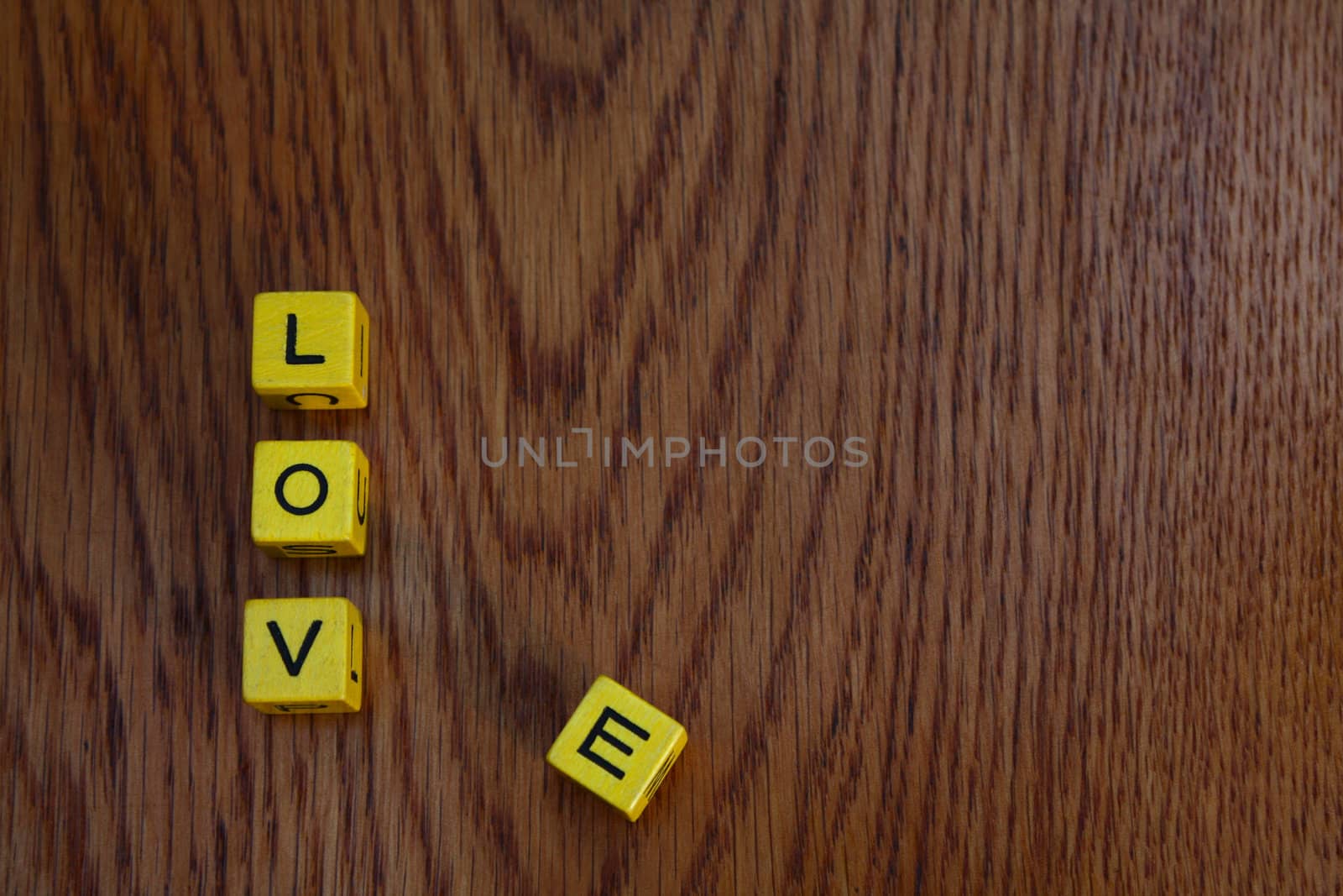 Yellow blocks on wooden surface spelling Love