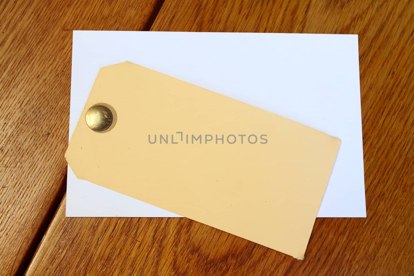 Yellow and white tag with a pin on wooden table