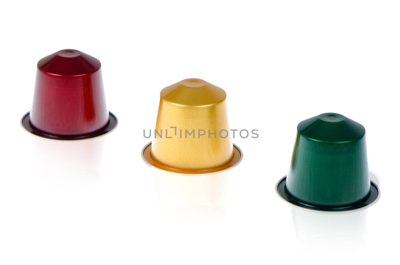 Coffee capsules for a coffee machine, close up view on white reflective background.