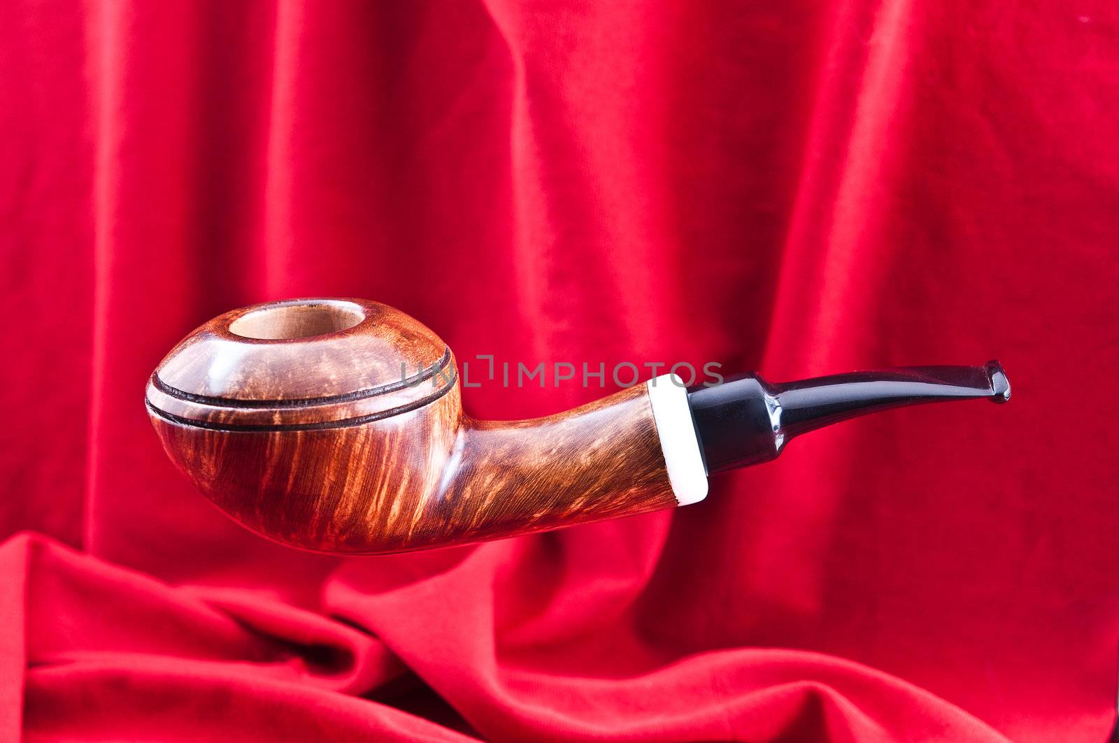 A new pipe for tobacco smoking was photographed against a red background