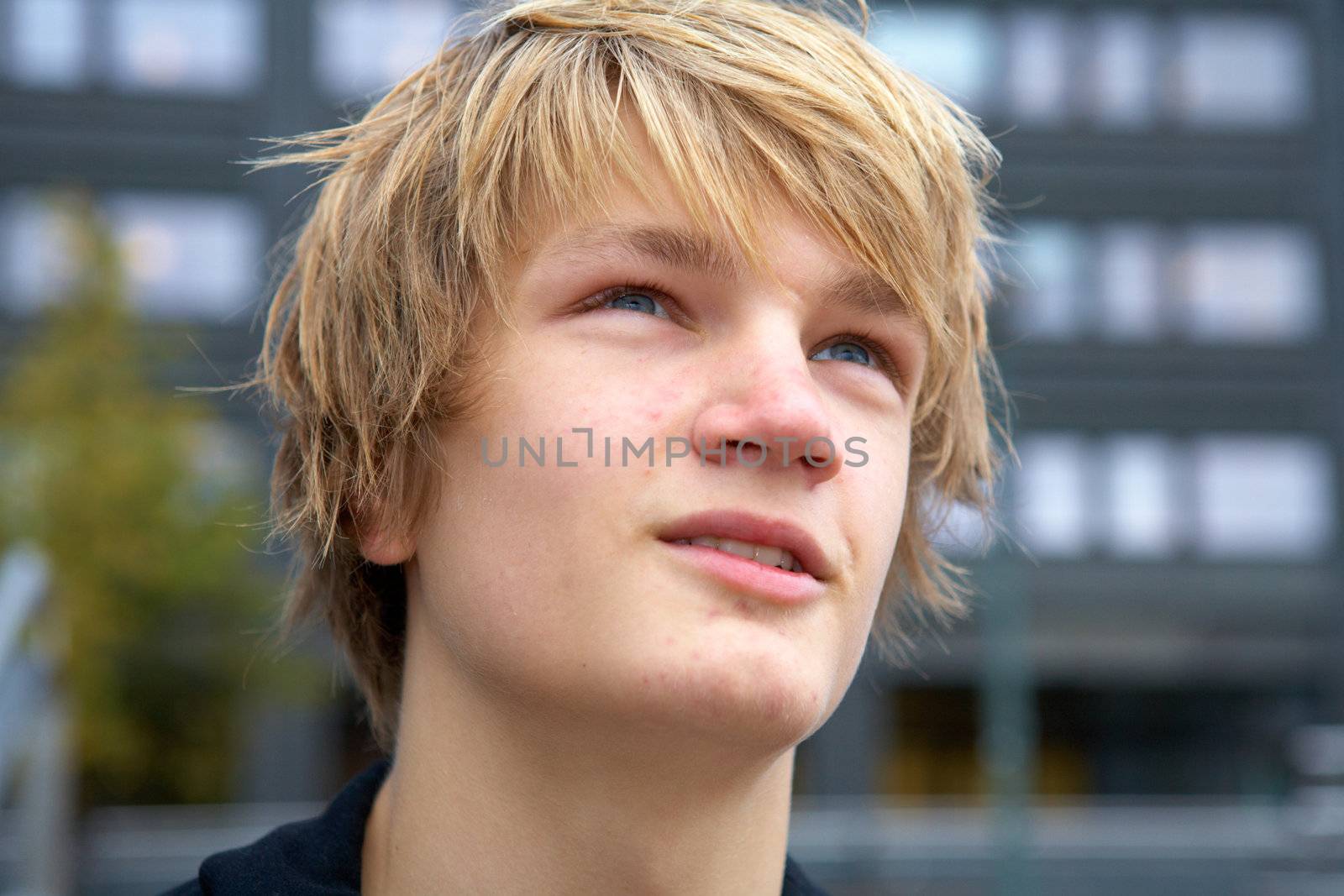 Portrait of hopeful teenage boy outdoor in city, close-up