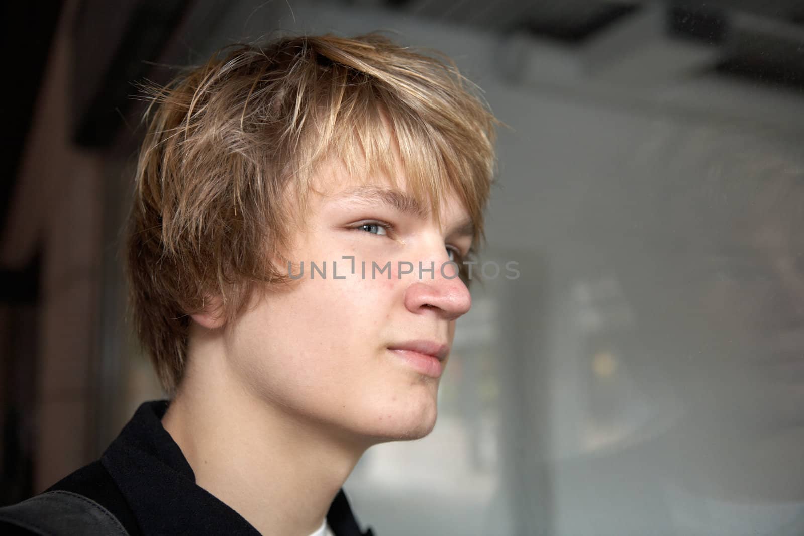 Teenage boy contemplating in city street, looking away