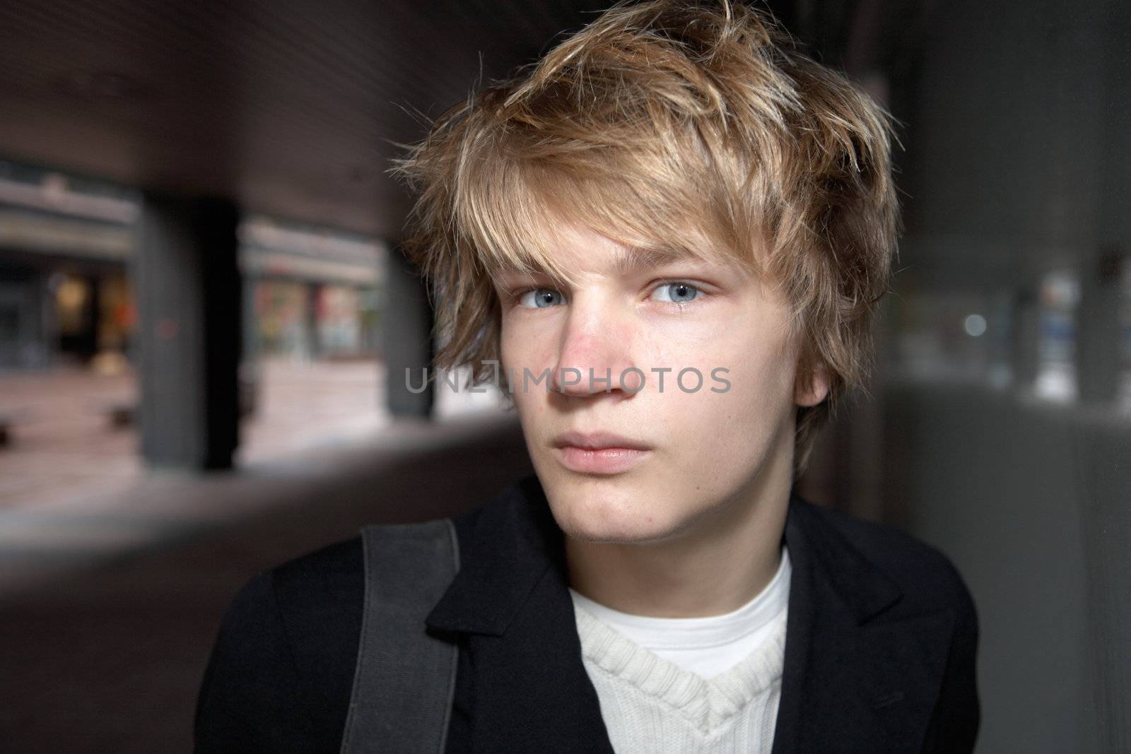 Portrait of teenage boy in city street, looking at camera