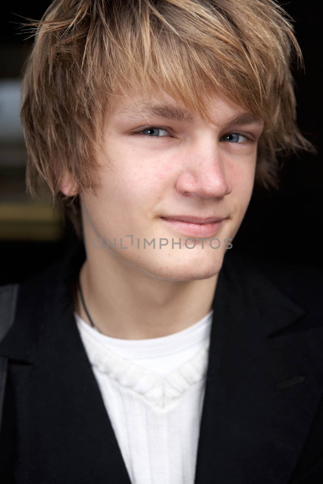 Close-up of teenage boy in street, smiling