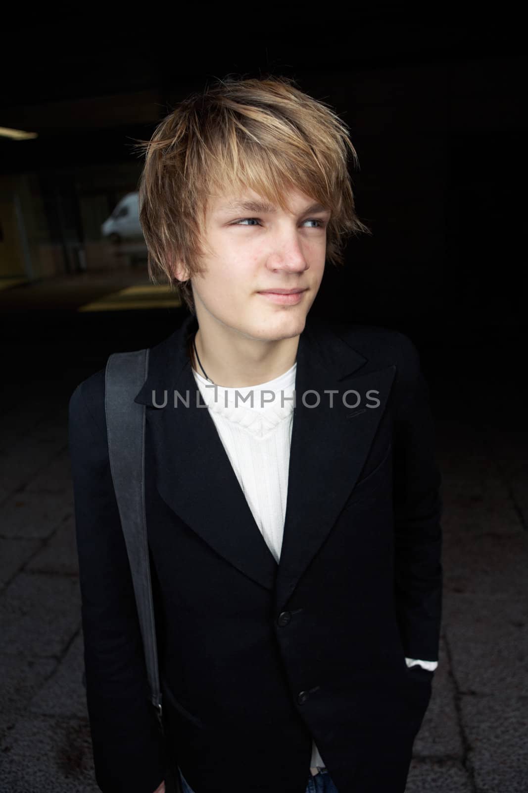 Portrait of happy teenage boy in street, looking away