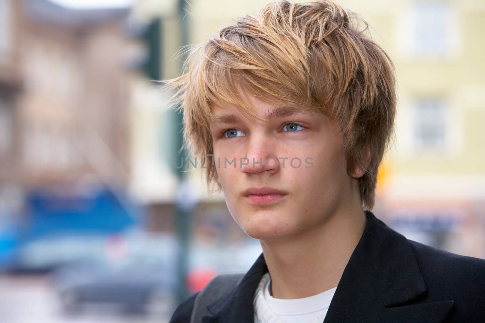 Portrait of teenage boy in street, looking away