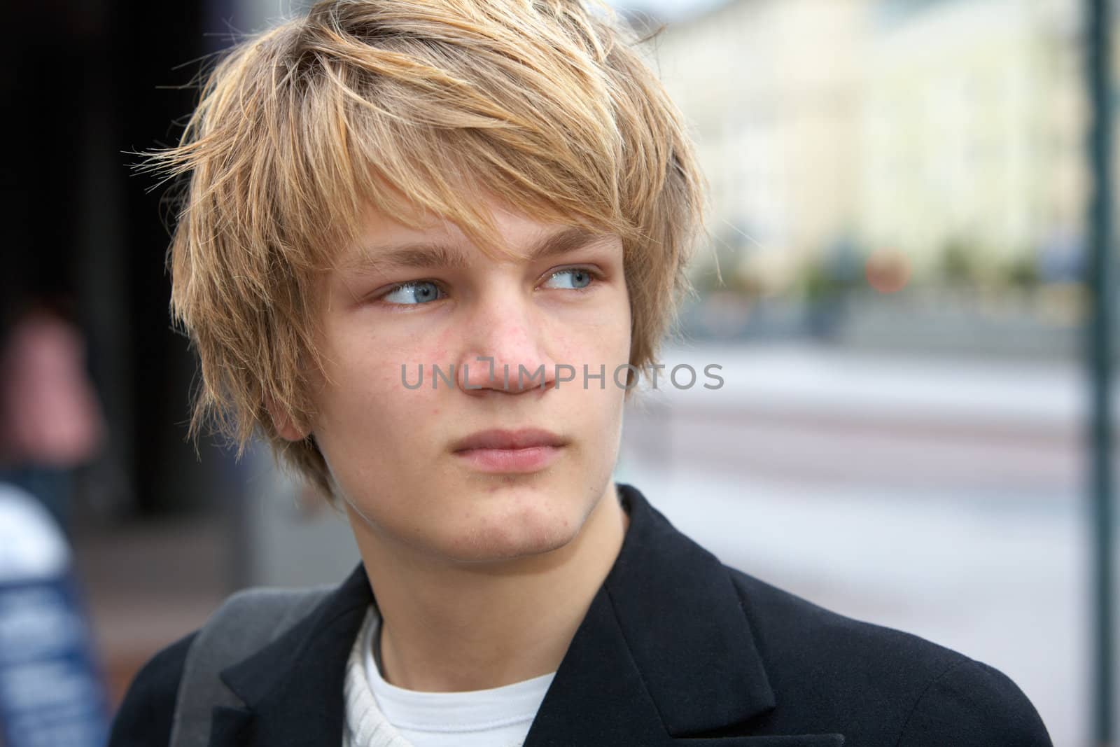 Portrait of contemplating teenage boy in street, looking away