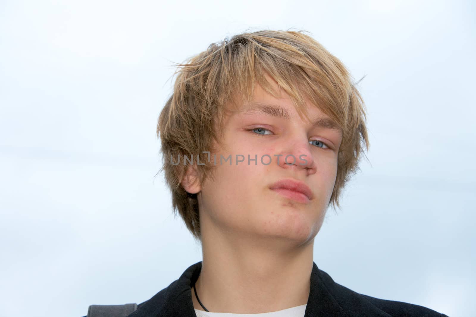 Portrait of teenage boy against sky, looking at camera