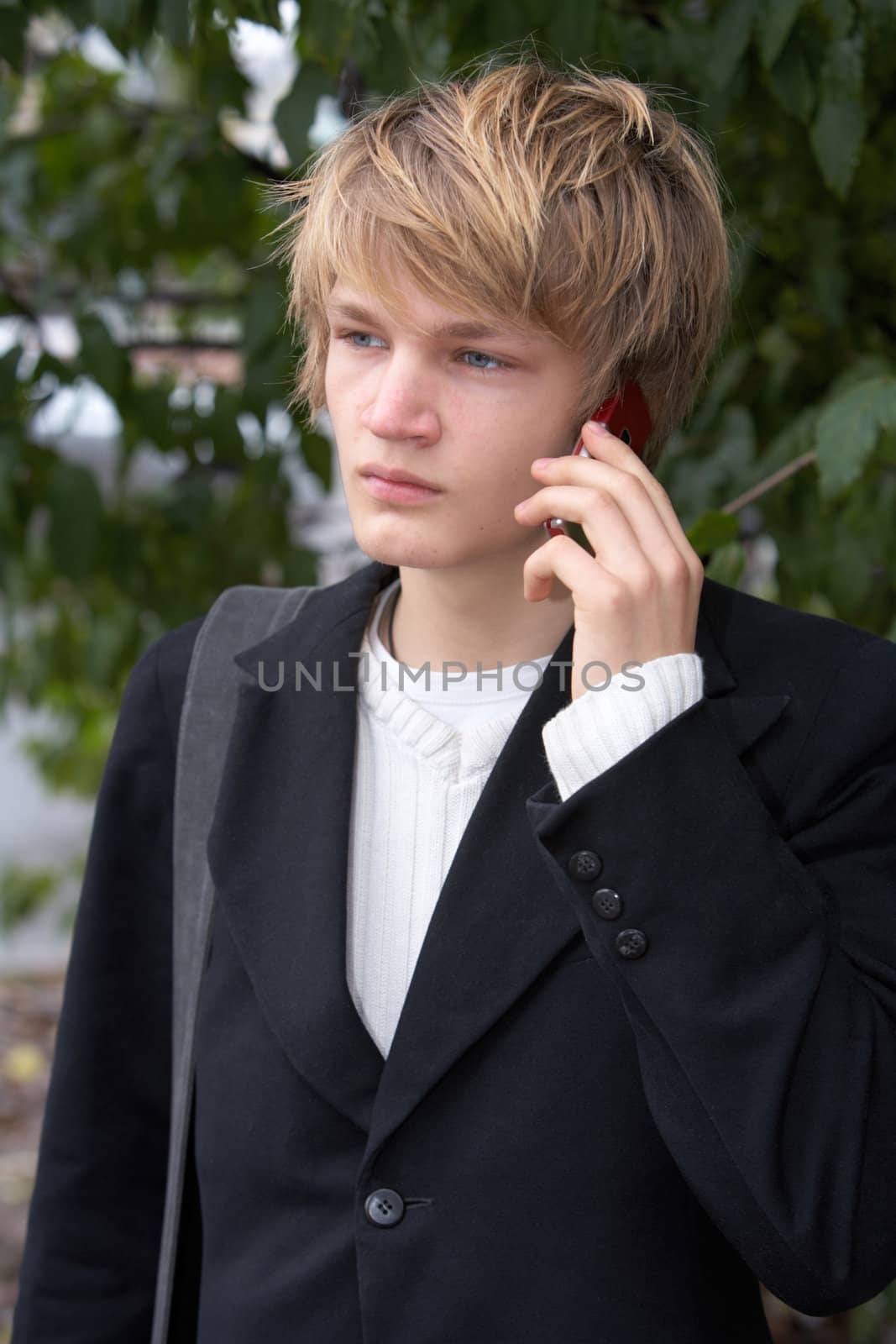 Teenage boy using mobile phone in city park