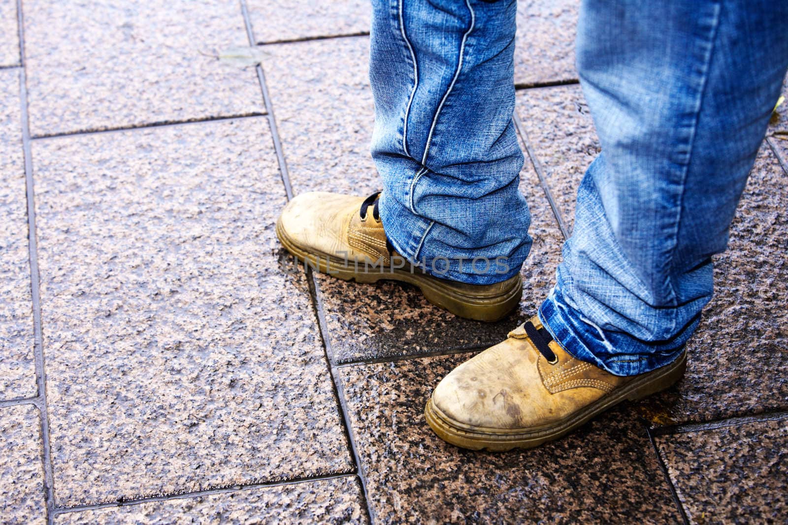 Close-up of feet of person standing in street