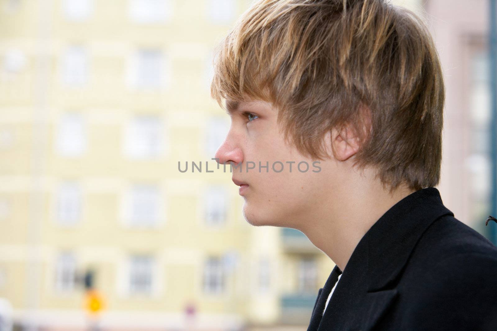 Teenage boy side profile, building in background