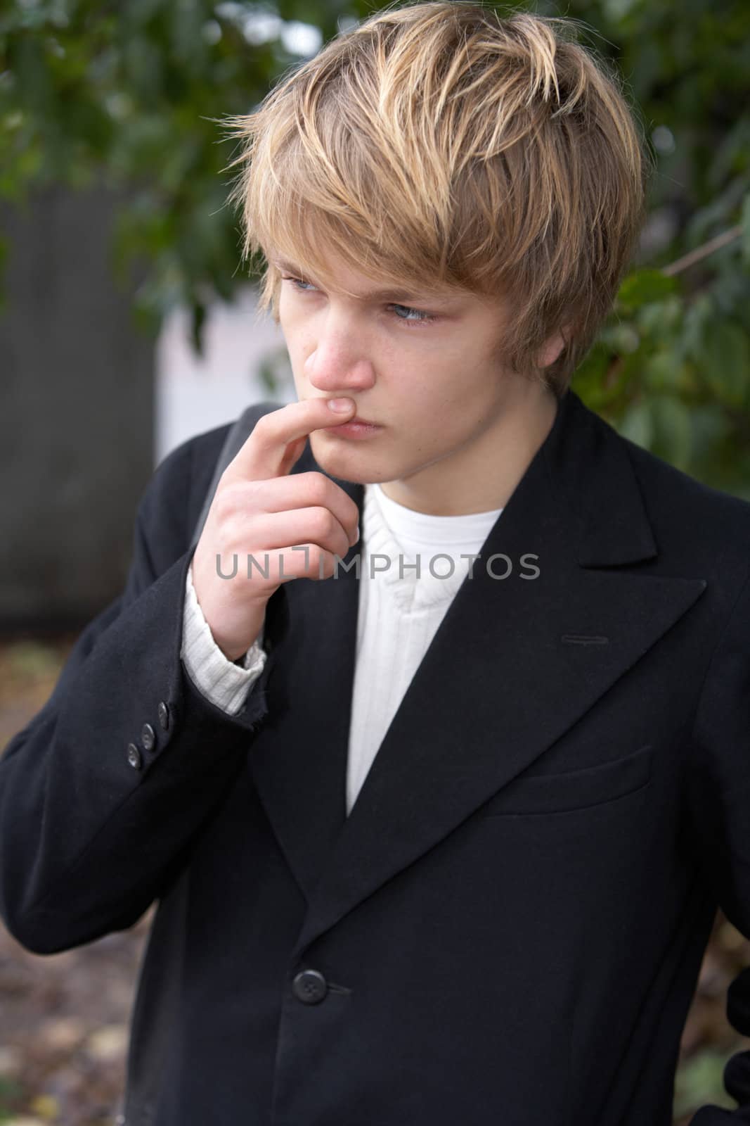 Teenage boy contemplating in city park