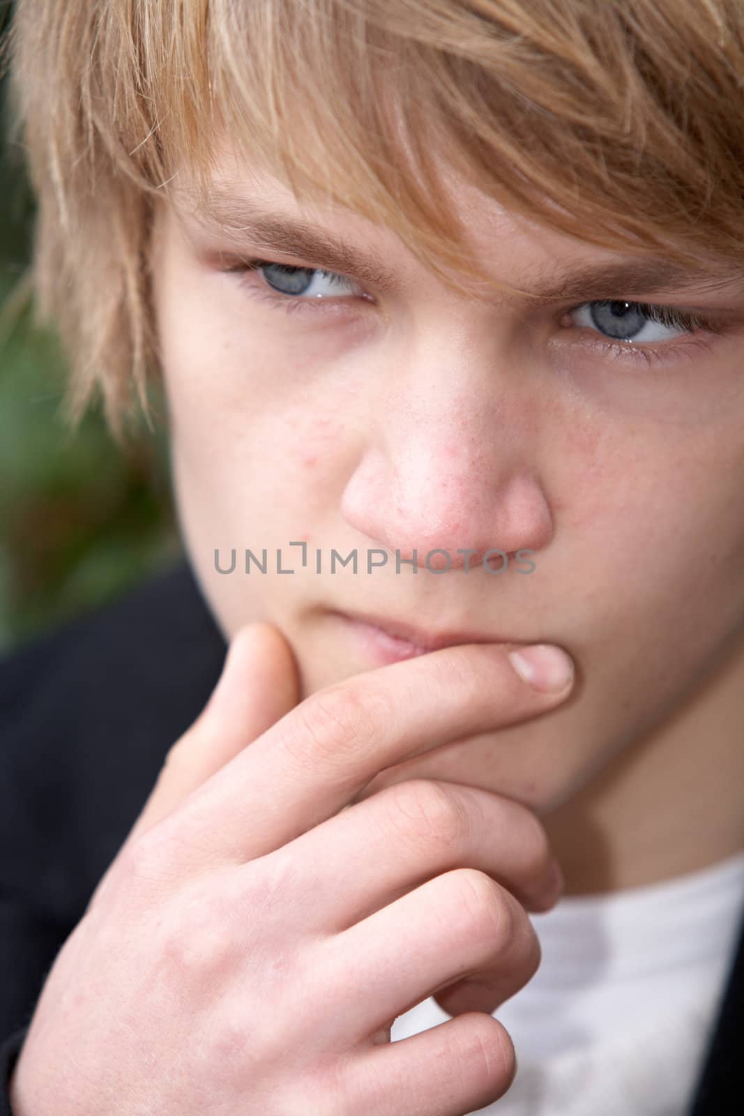 Teenage boy contemplating in city park, close-up