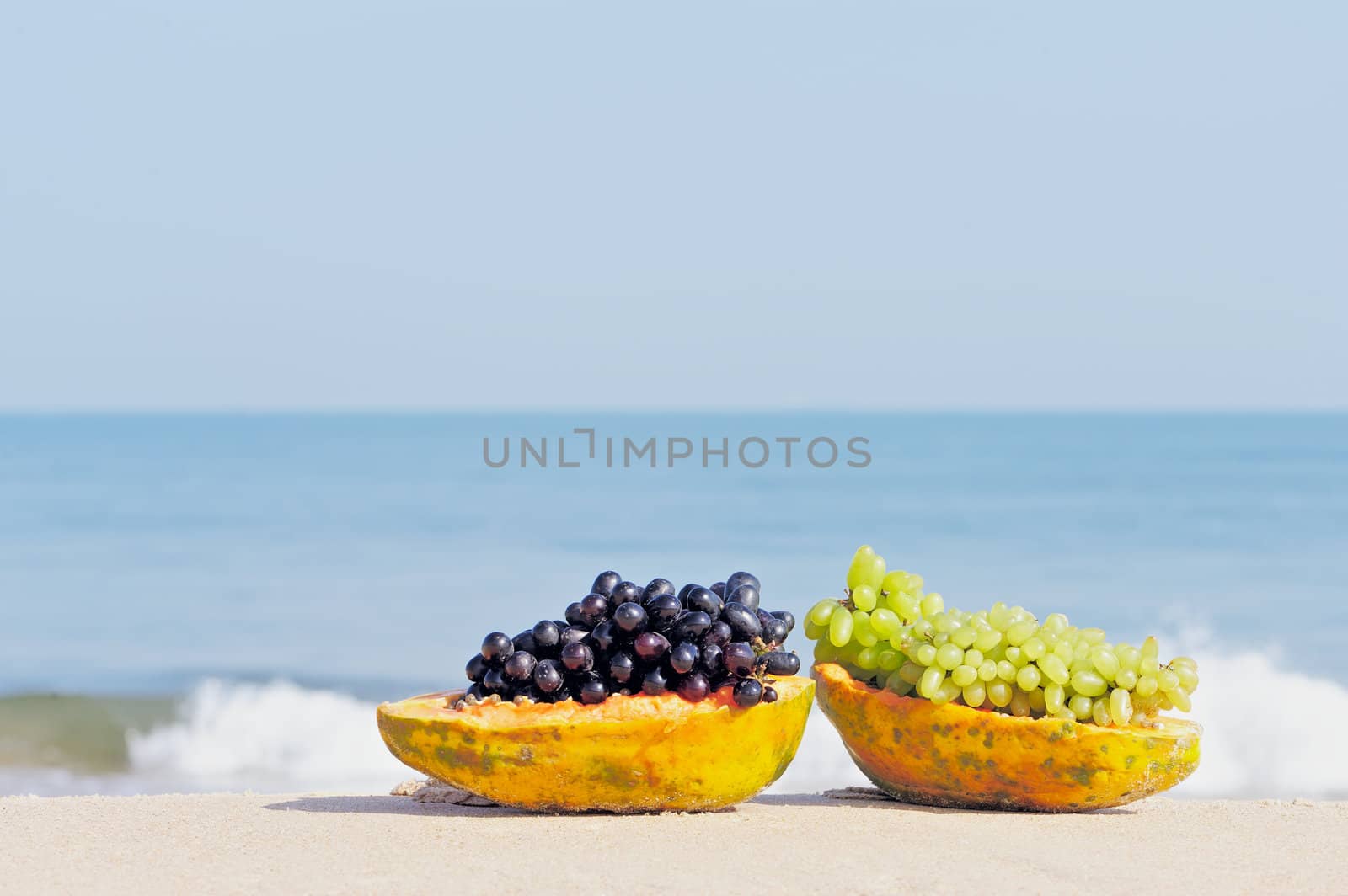 Papaya and grape on the tropical beach