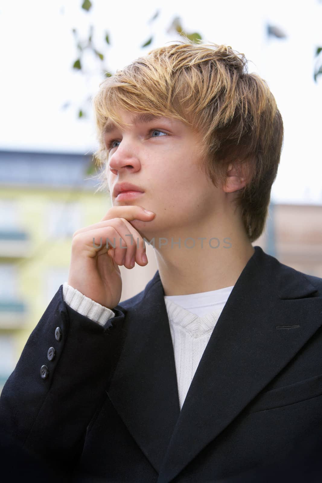 Teenage boy contemplating in city park, close-up