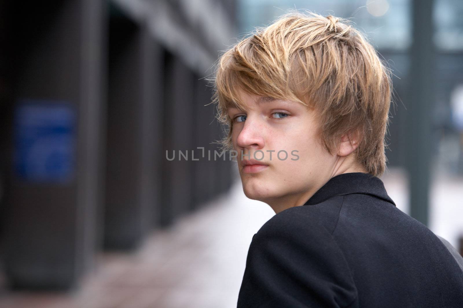 Teenage boy looking back over his shoulder, close-up
