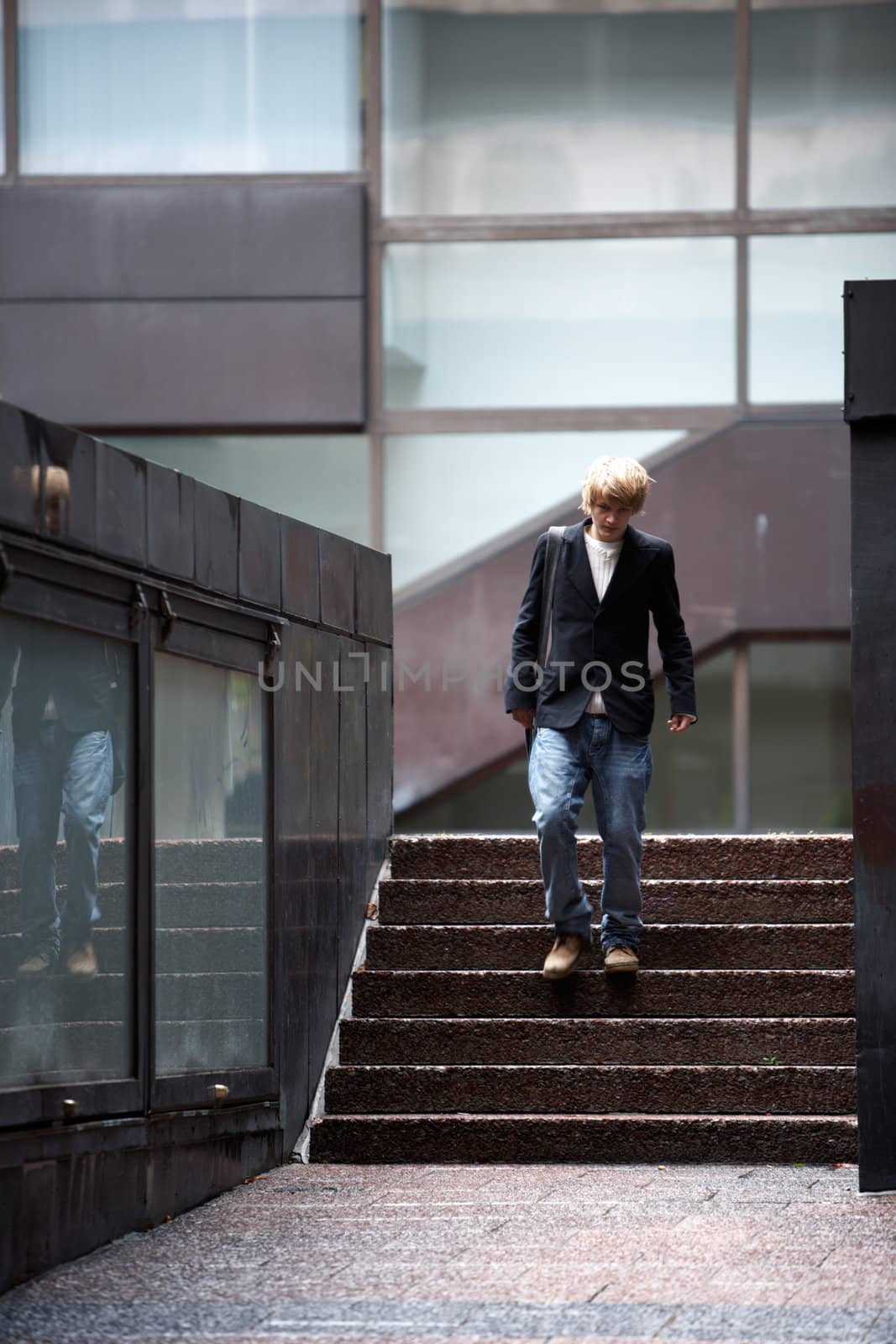 Teenage boy walking in stairway of building