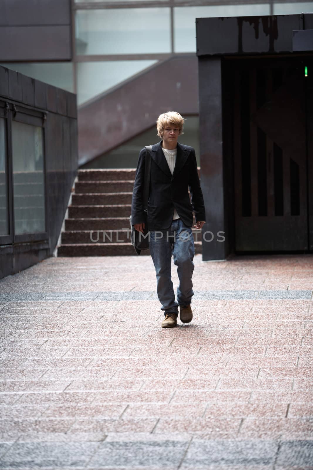 Teenage boy walking at entrance of building