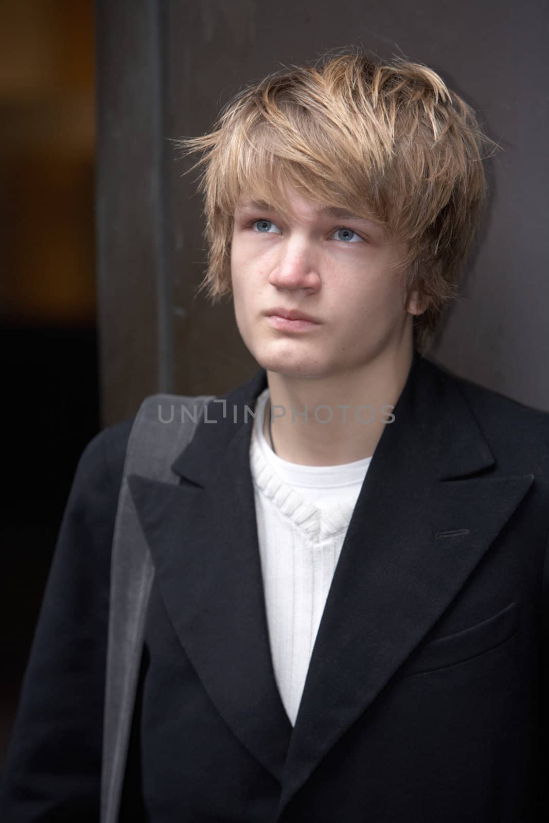 Portrait of teenage boy standing in street, looking up