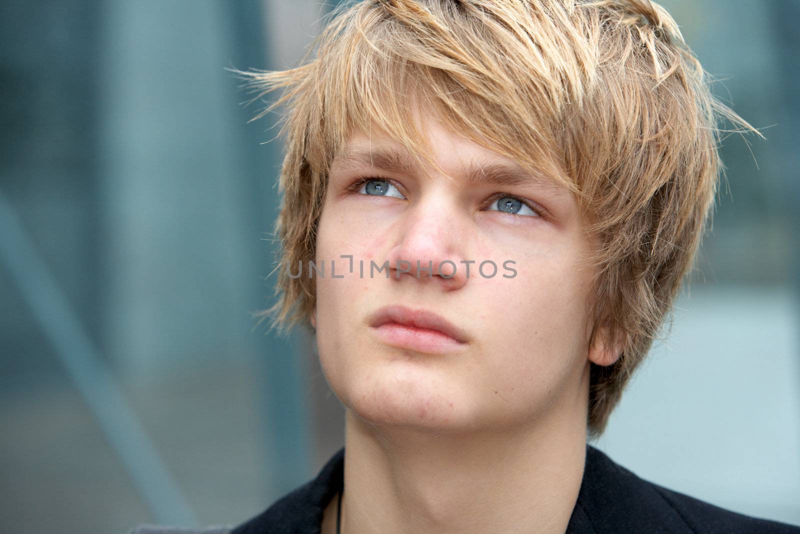 Pensive teenage boy in urban environment, close-up