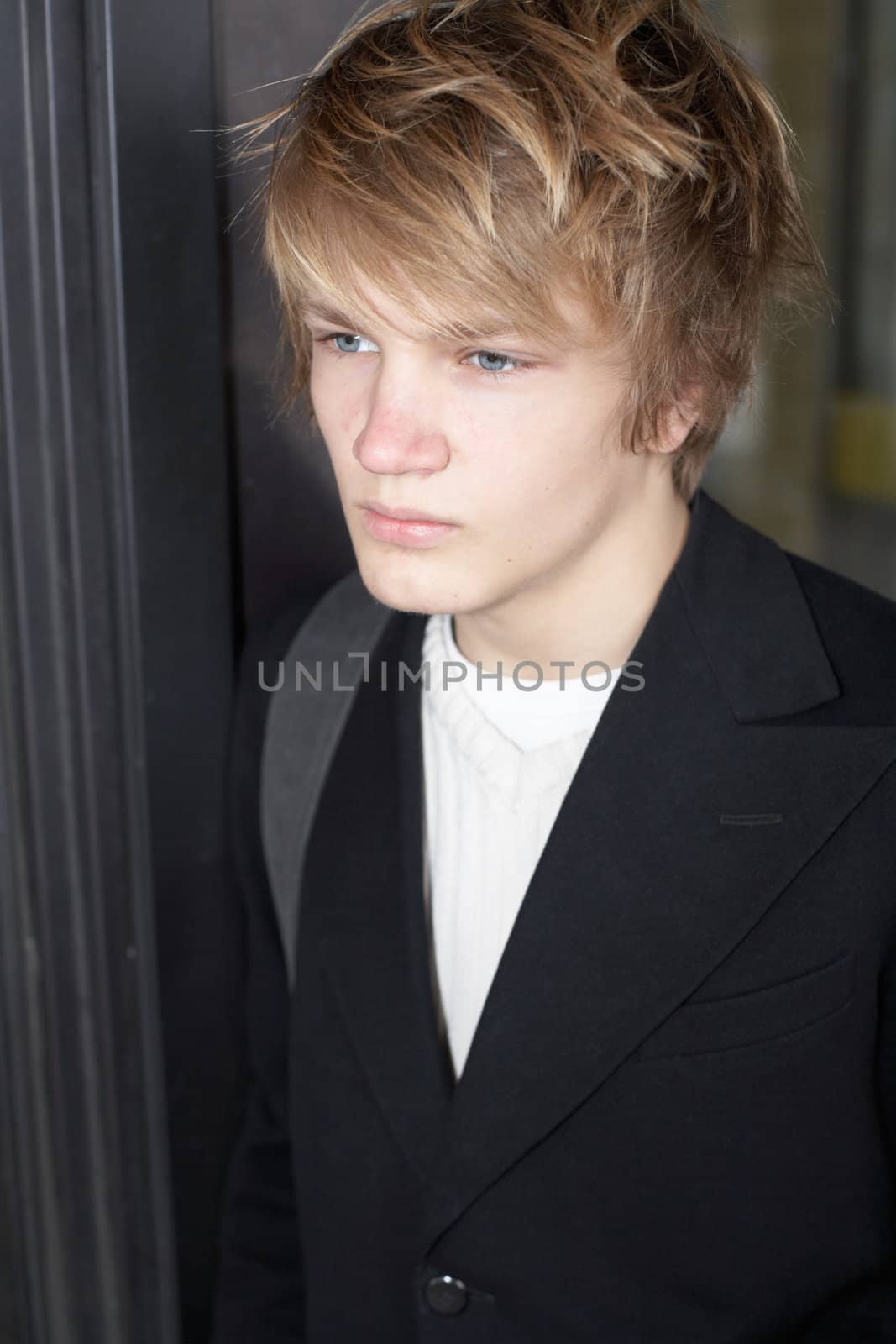Portrait of teenage boy standing by metal door