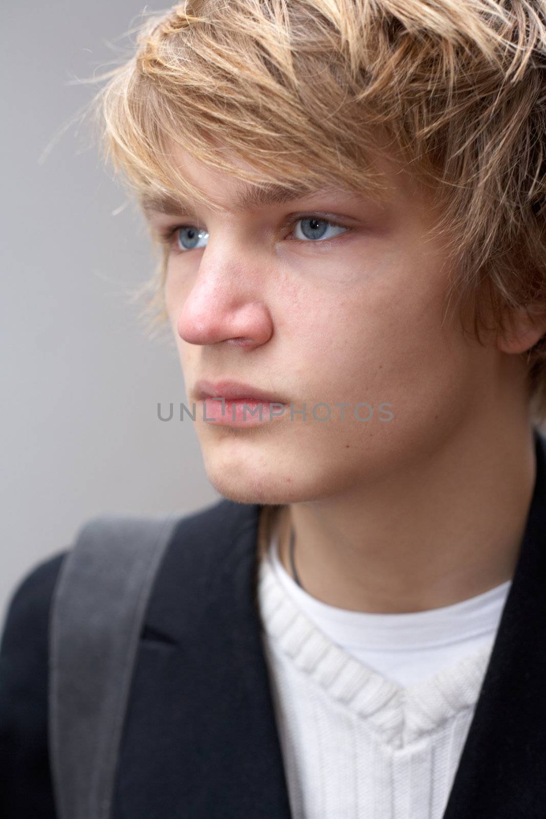 Exterior portrait of serious teenage boy, close-up