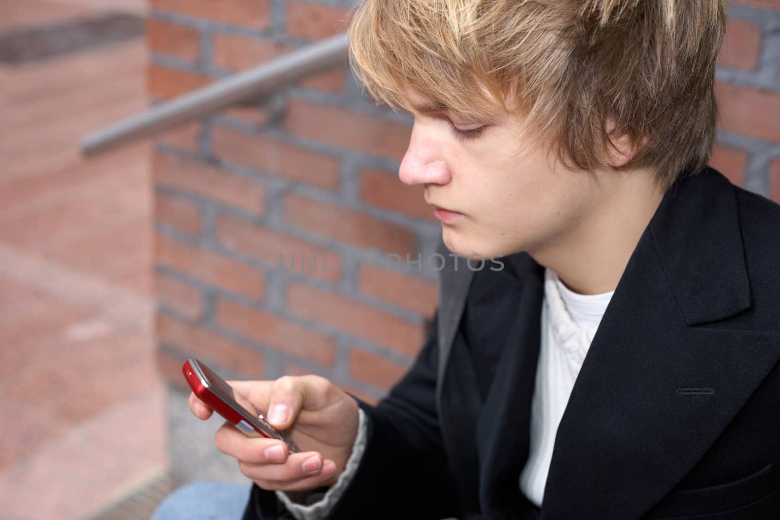Teenage boy text messaging with mobile phone