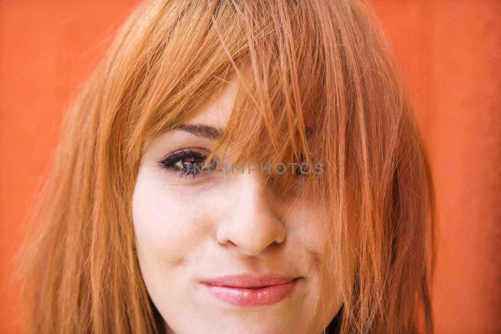 Young redheaded woman looking at viewer with funny expression.