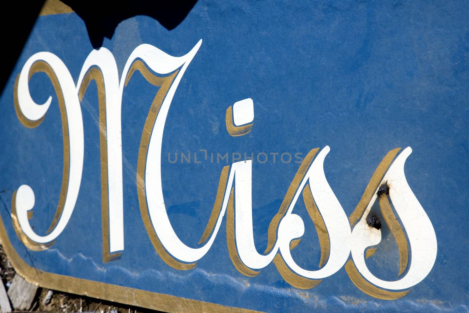 Blue sign with the word "Miss" in cursive written on it.