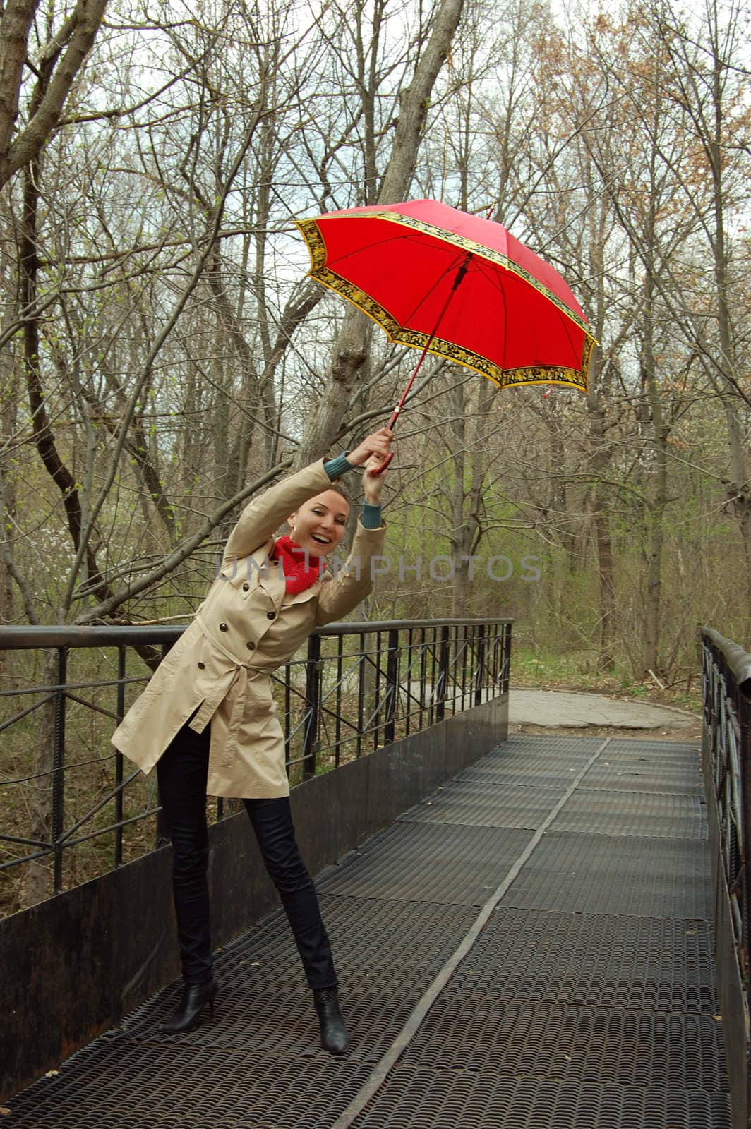 happy girl with red umbrella on bridge