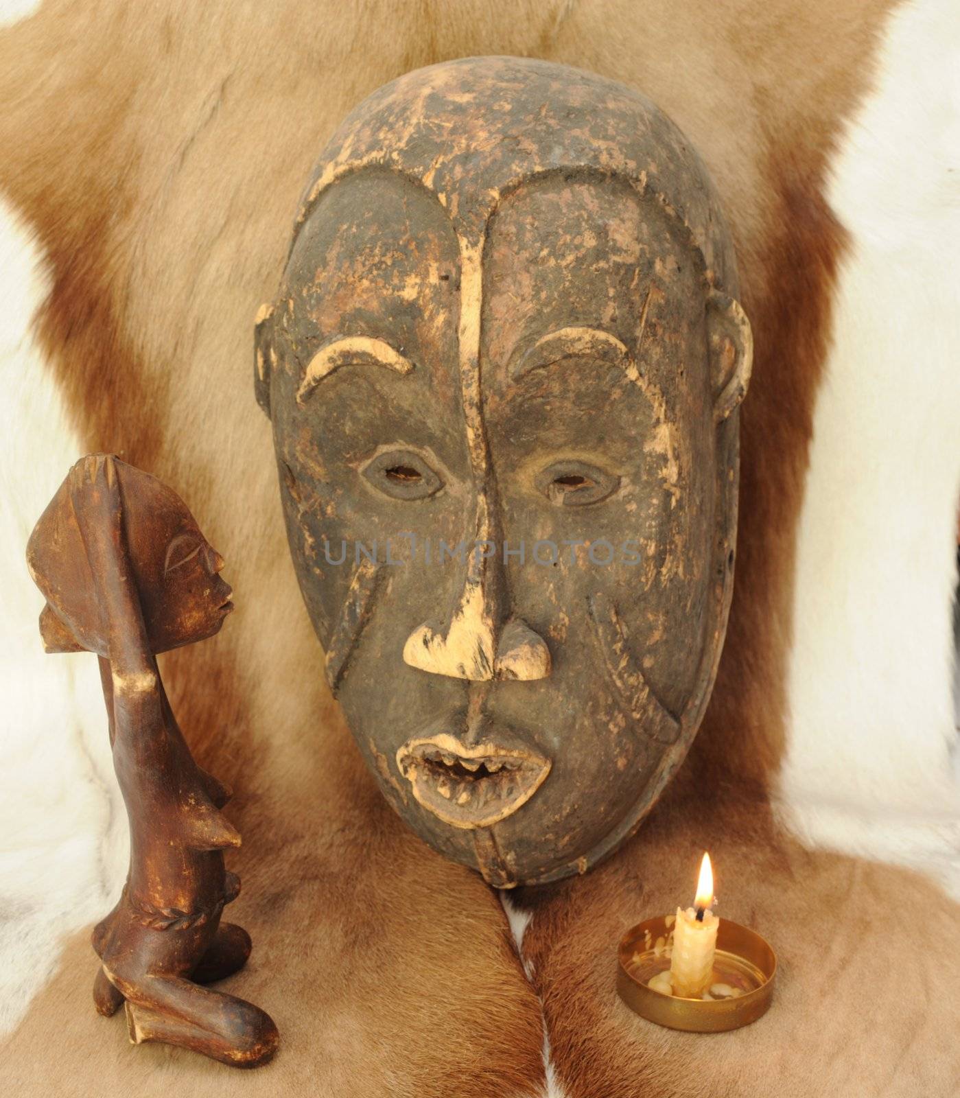 African Mask and Praying Wooden Figure on 
Natural Animal Fur.