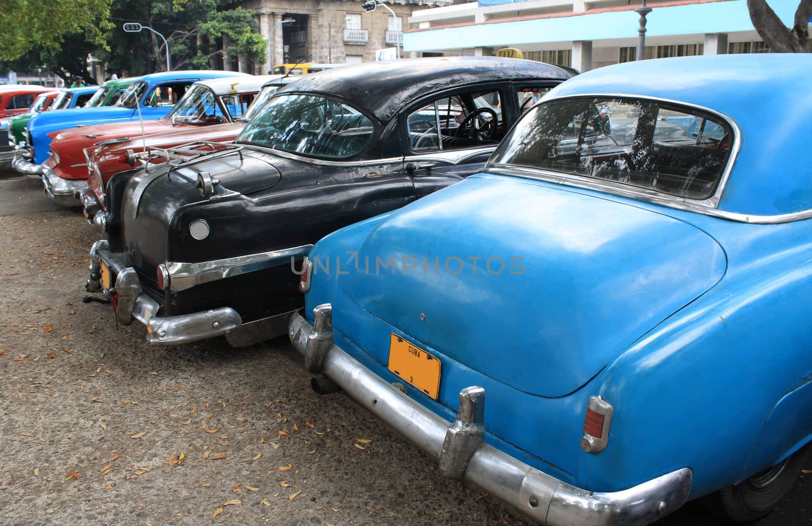 Colourful vintage taxis parked in a street in Havana, Cuba. Rear view.