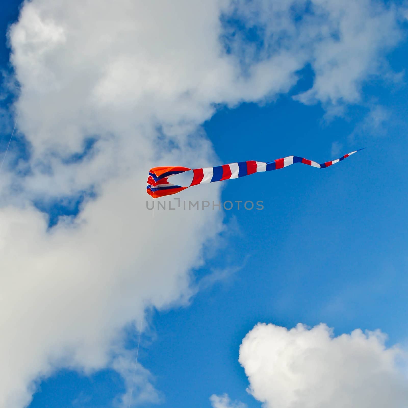 a striped kite flying in the sky