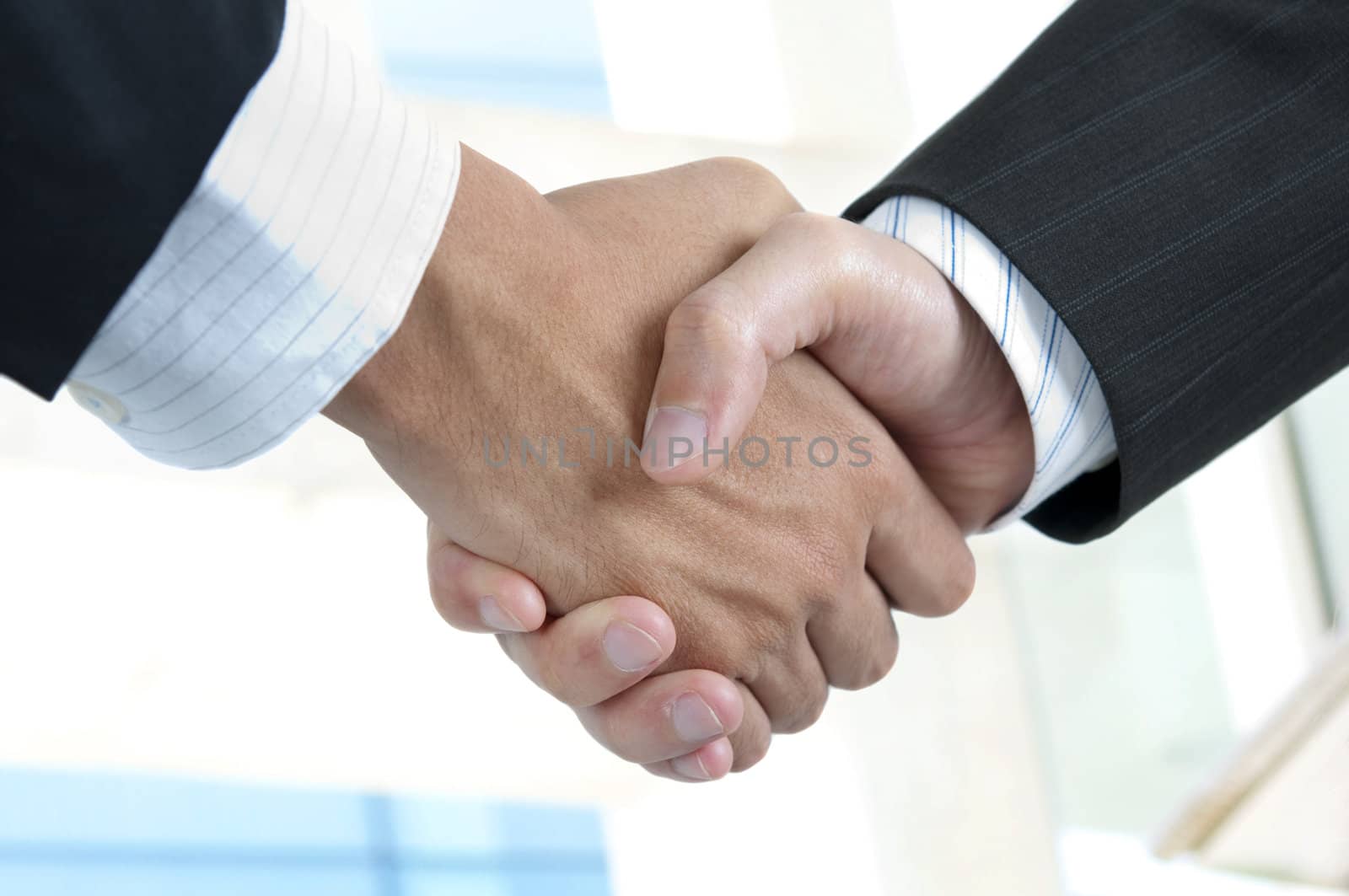 Asian businessman handshake with modern skyscrapers as background