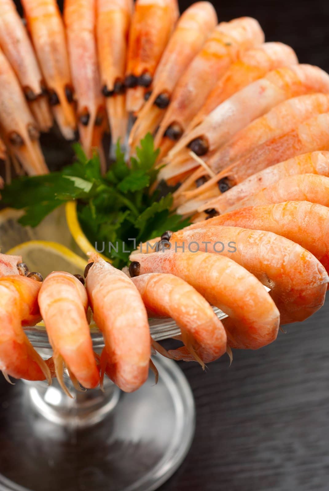 tasty shrimps with lemon and greens closeup