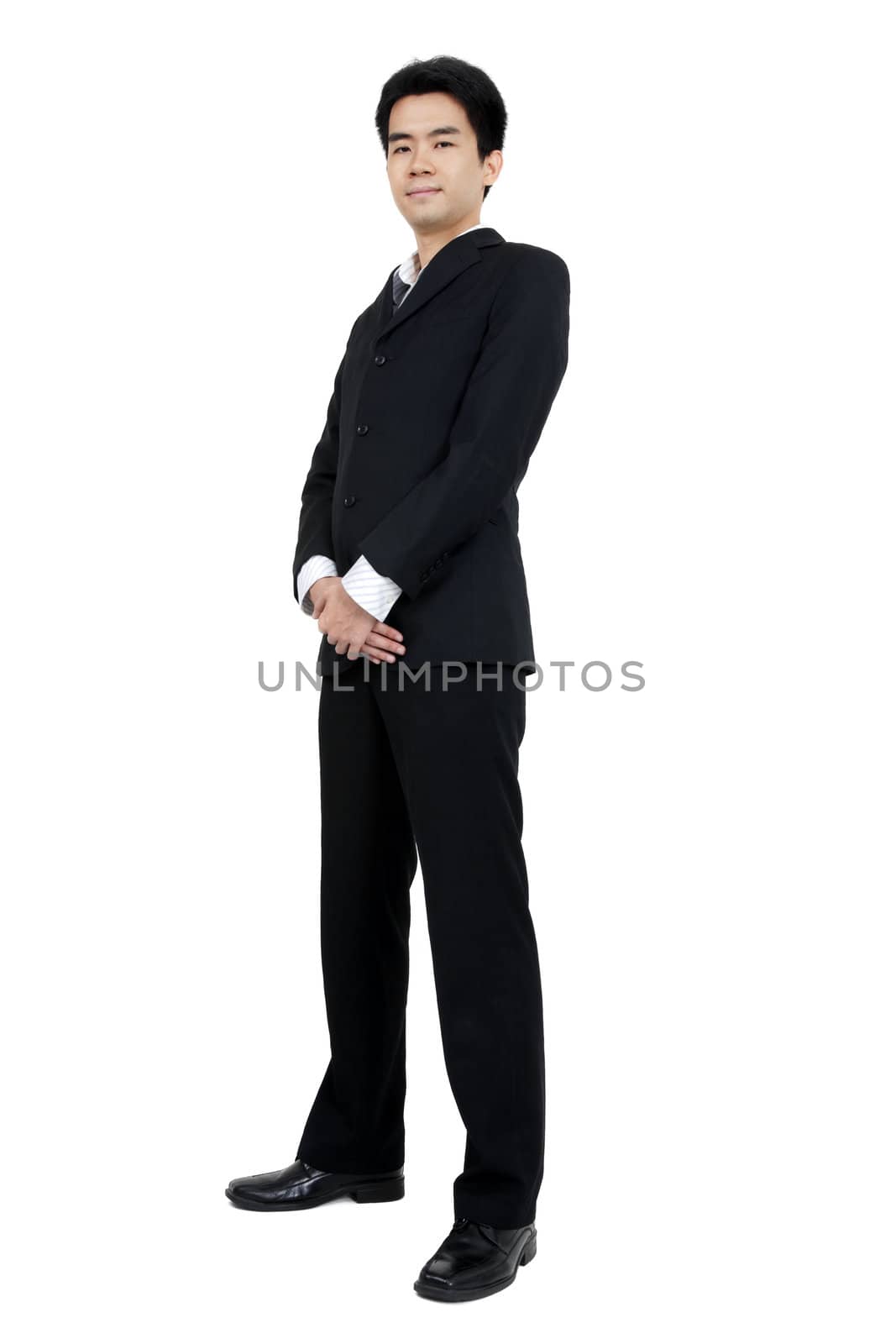 Full length of a smiling young Asian executive standing against isolated white background