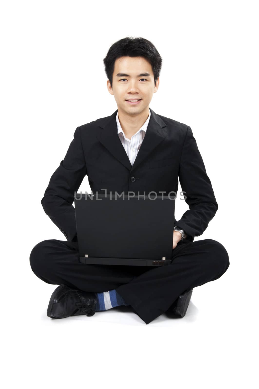 Asian business man sitting on floor with laptop