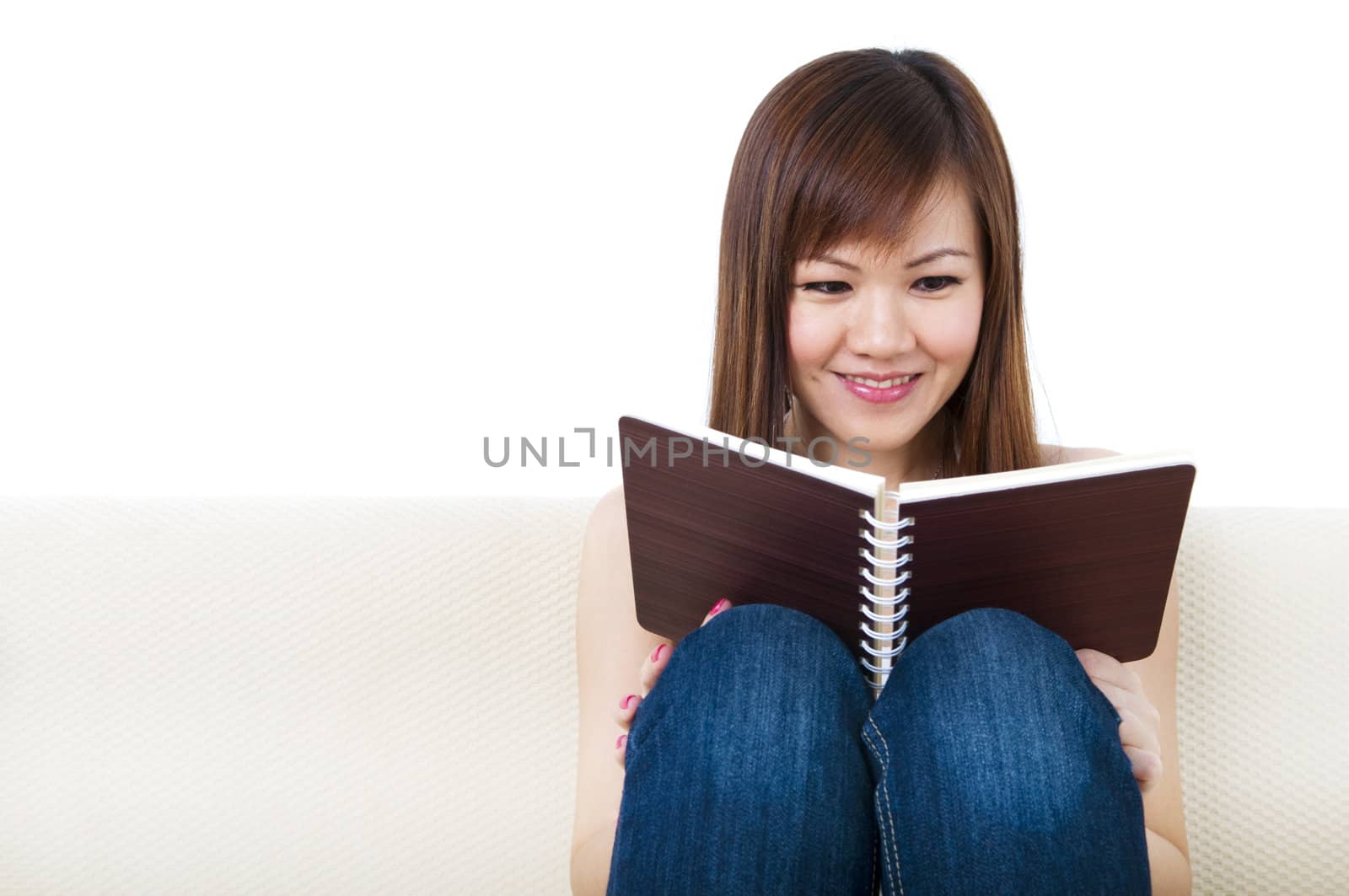 Women Reading an Interesting Book on Sofa