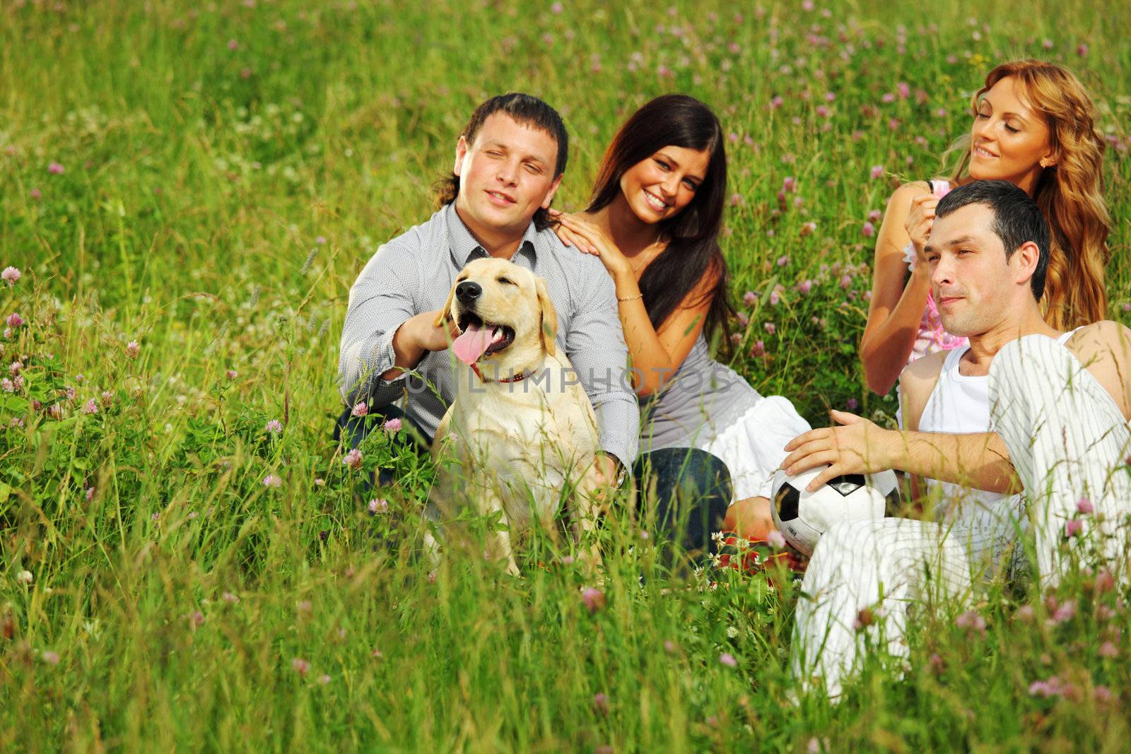 friends and dog in green grass field