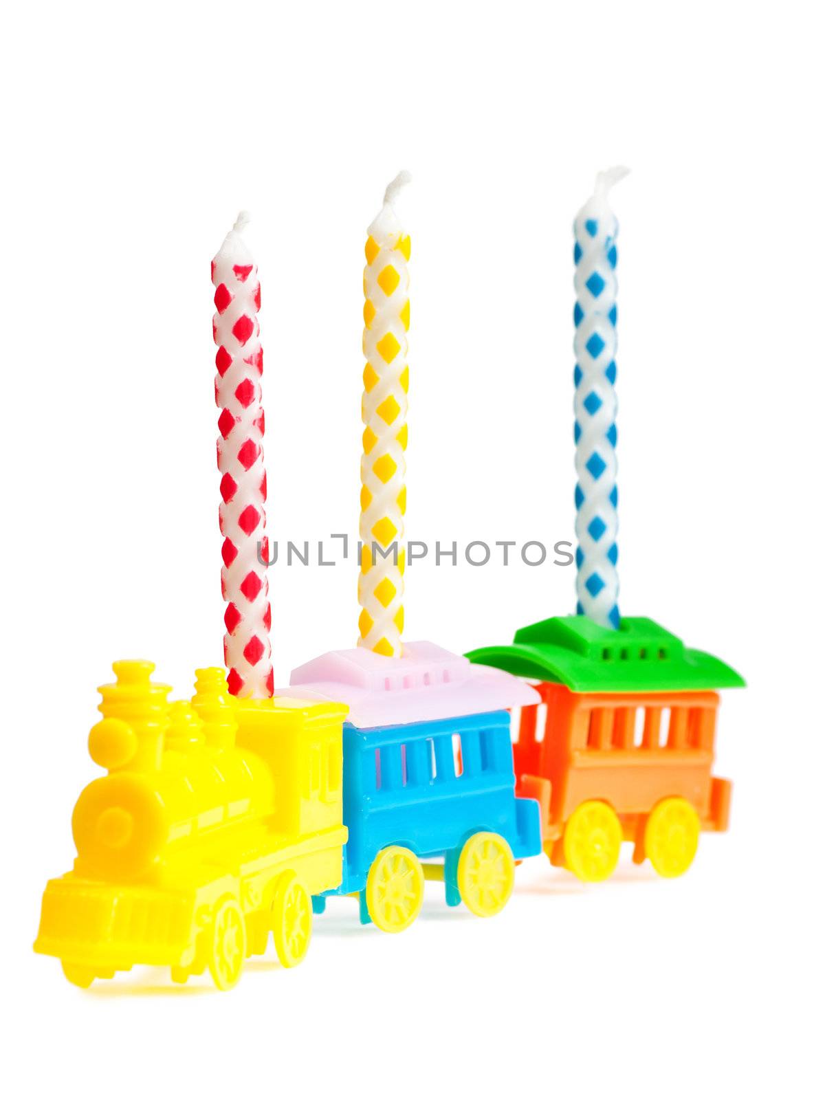 Macro view of three birthday candles in a train-shaped support