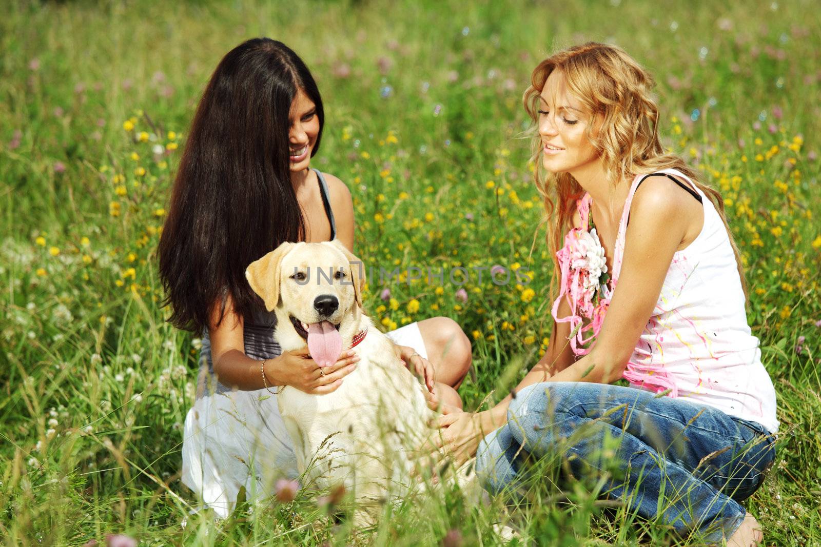 girlfriends and dog in green grass field