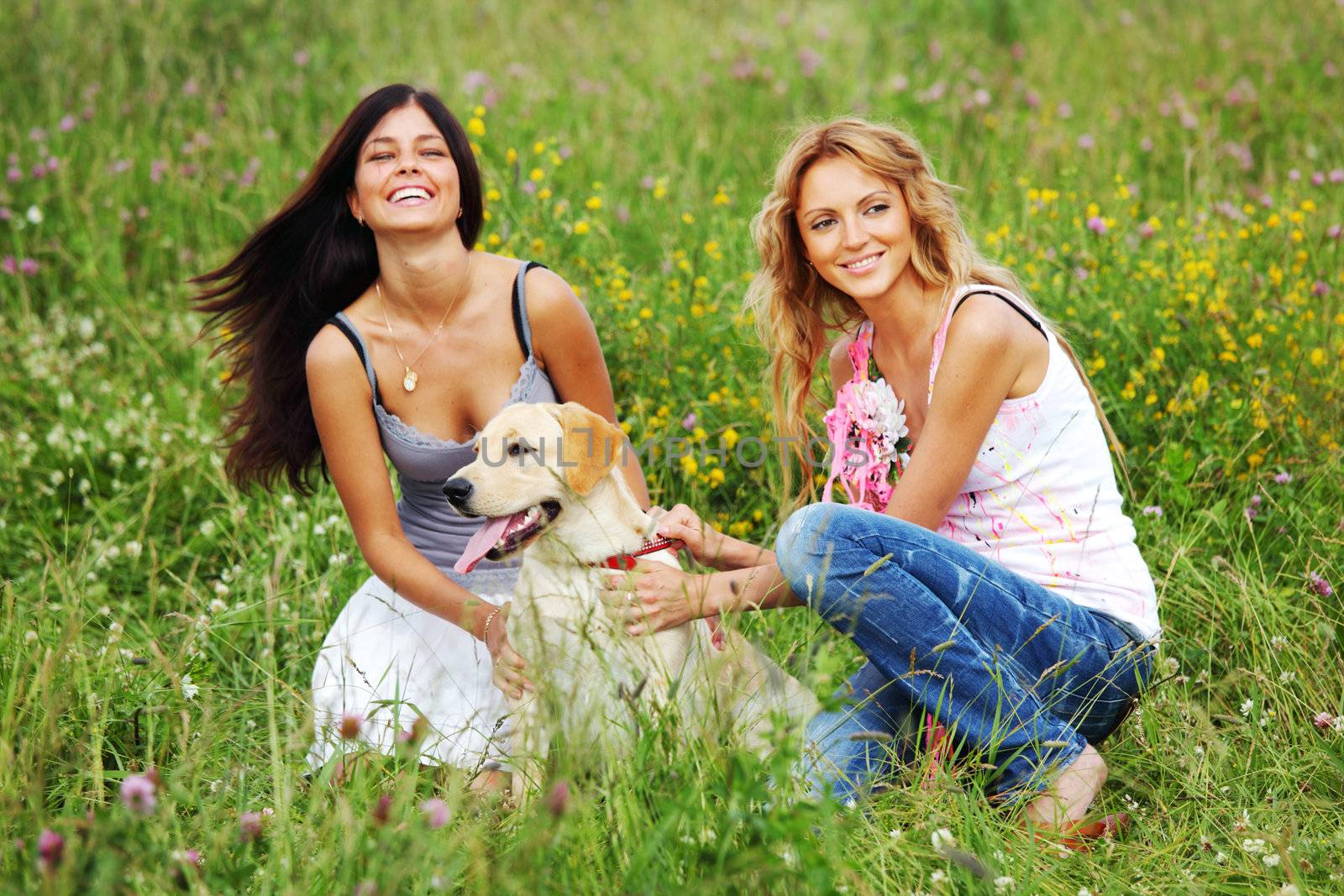 girlfriends and dog in green grass field