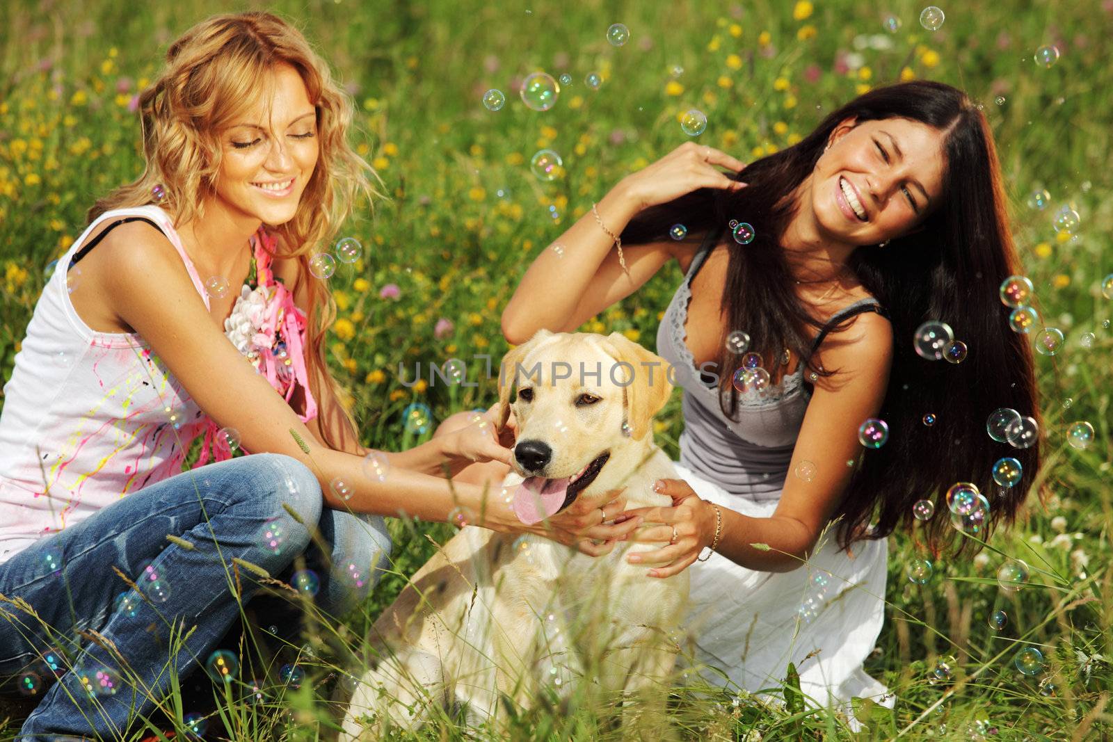 girlfriends and dog in green grass field