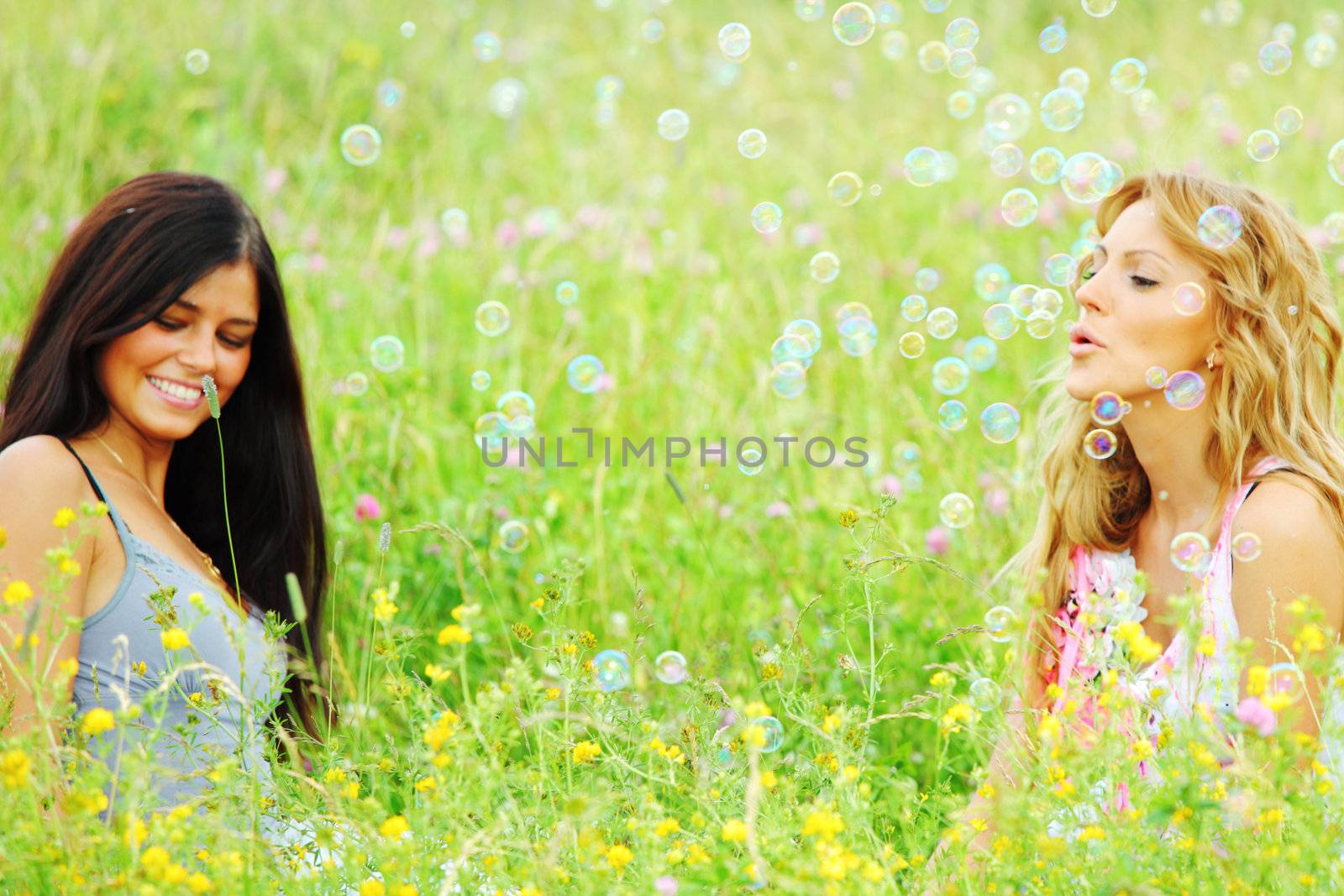 girlfriends on green grass field in soap bubbles