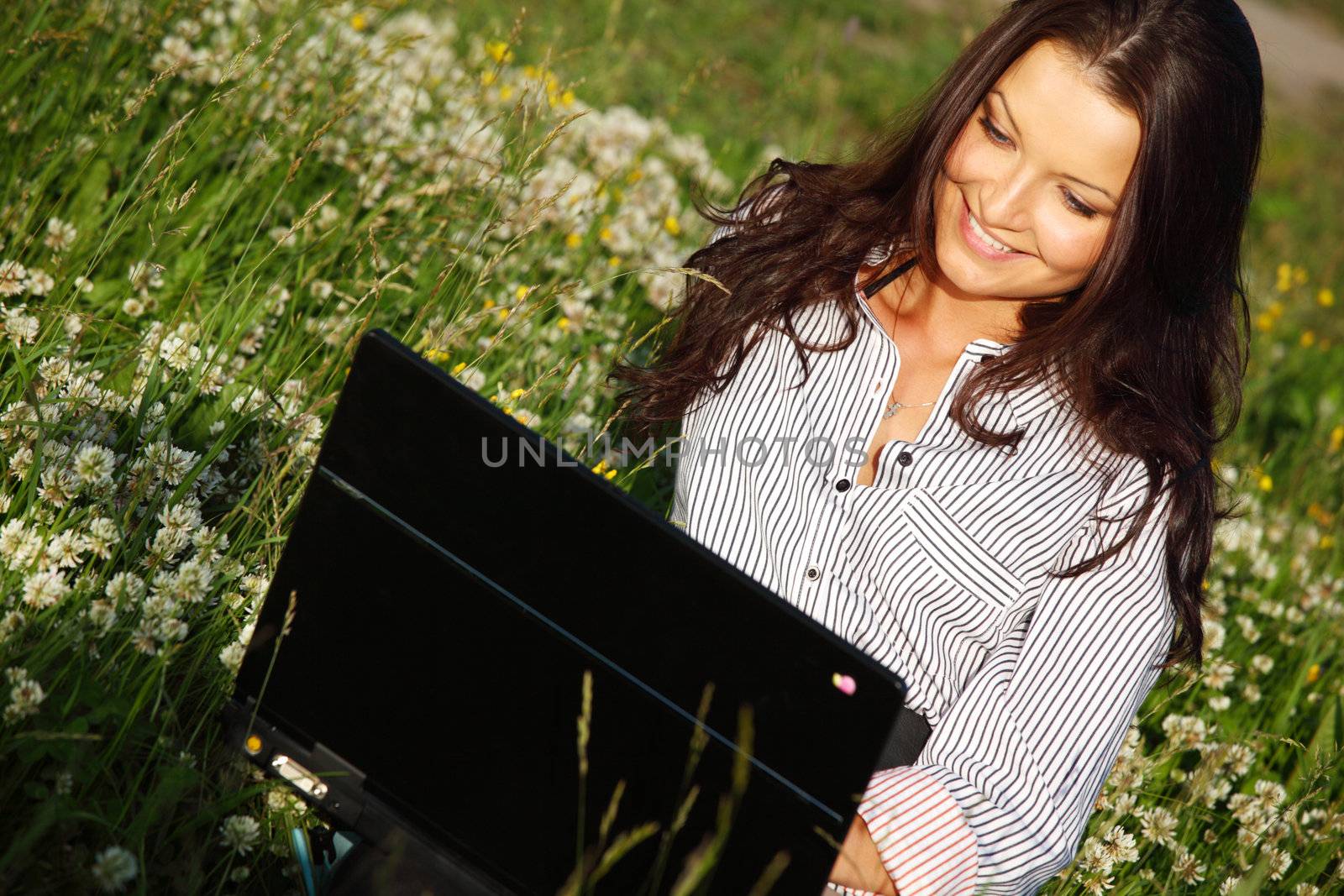 girl with laptop on green grass