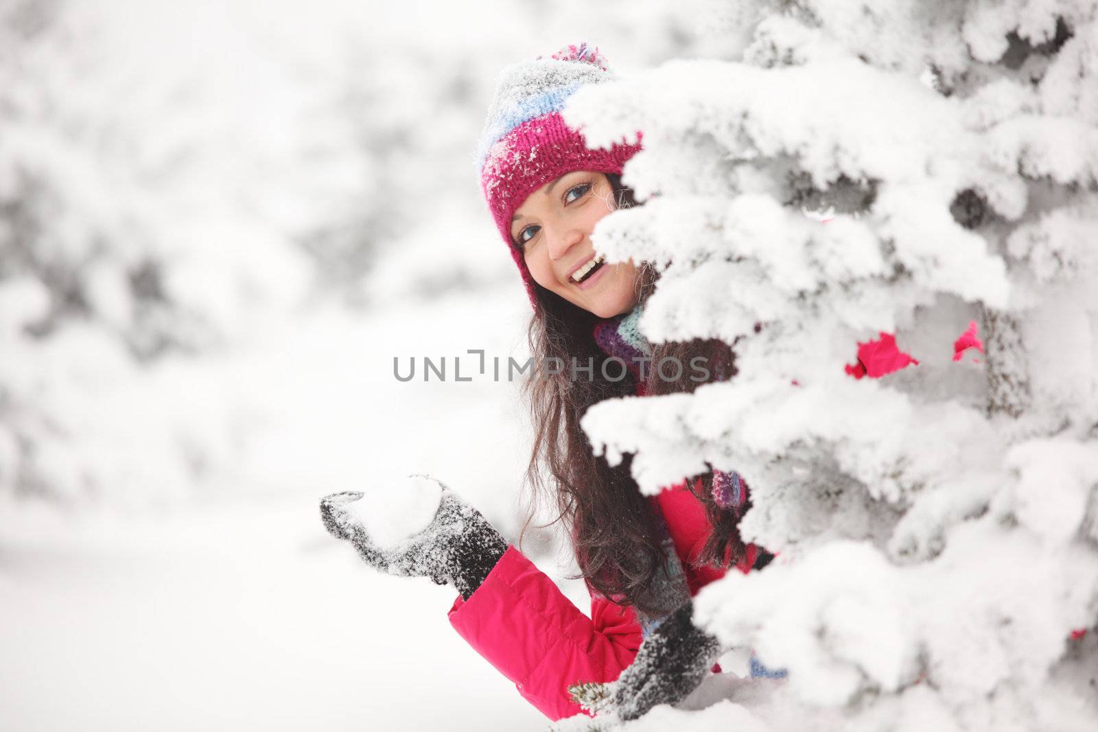 winter woman play snowballs on snow background