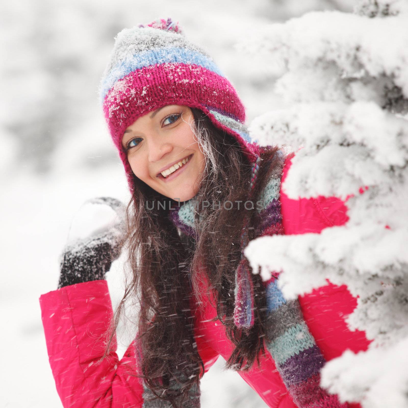 winter woman play snowballs on snow background